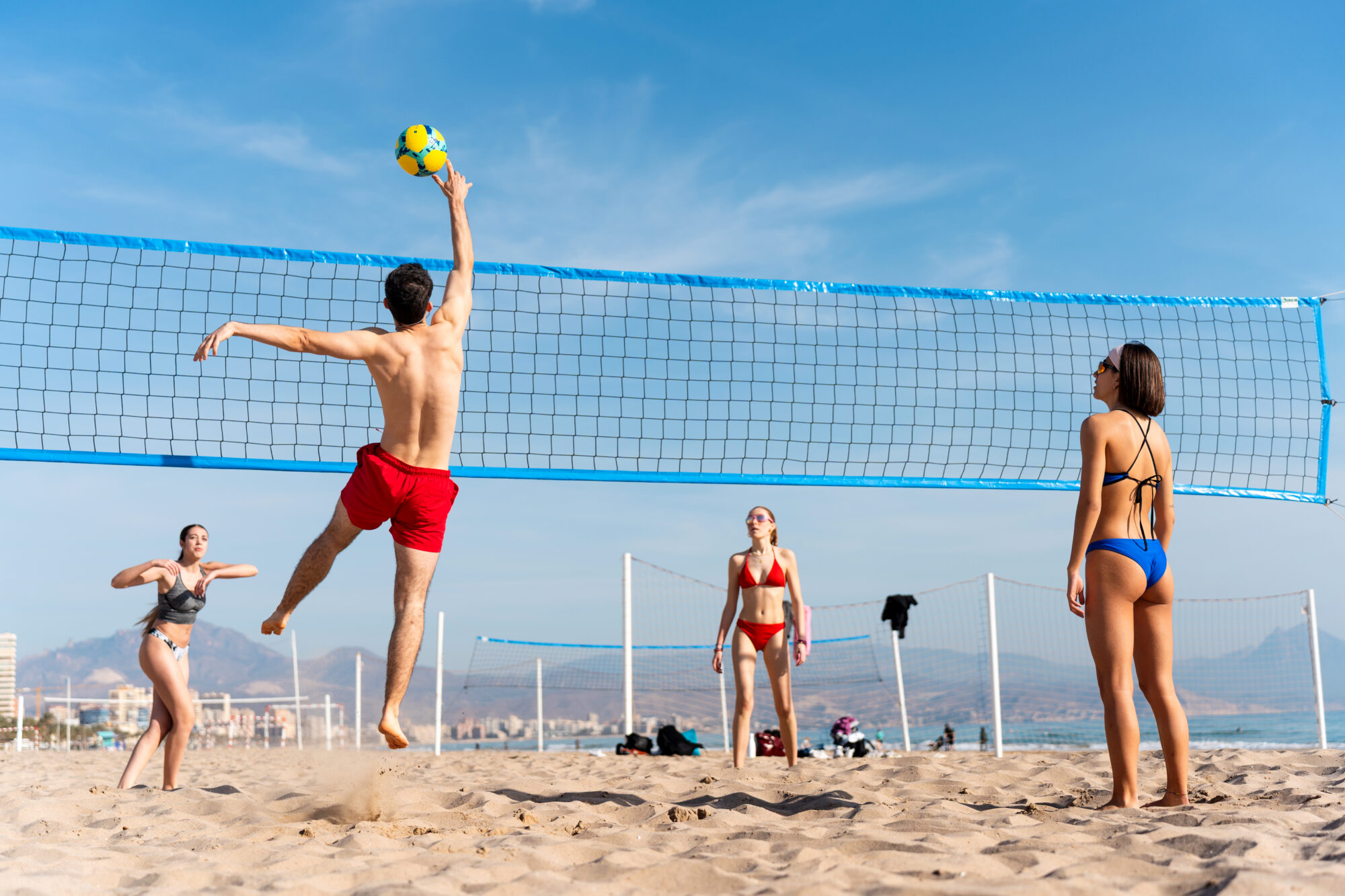 Studenti universitari giocano una partita di beach volley durante un evento organizzato da UniCaland.