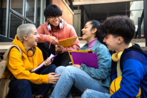 Gruppo di studenti universitari che socializza e studia insieme all'aperto negli spazi del campus Unicaland.