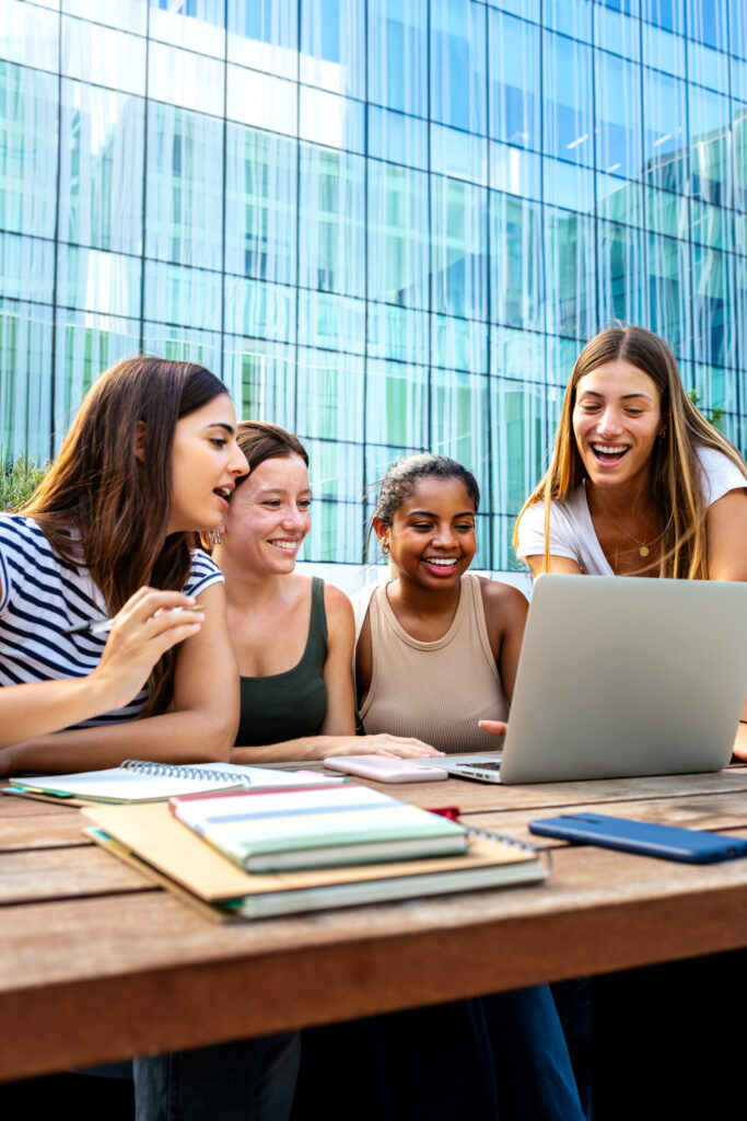 Gruppo di studenti universitari che studia insieme con un computer portatile in un'area comune di Unicaland.